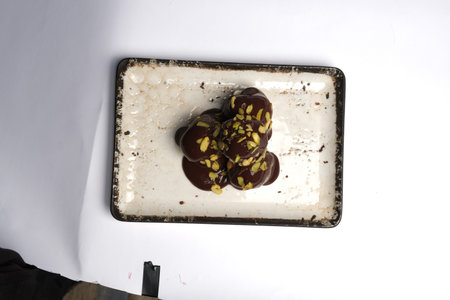 Chocolate truffles with pistachios on a white backgroundの写真素材
