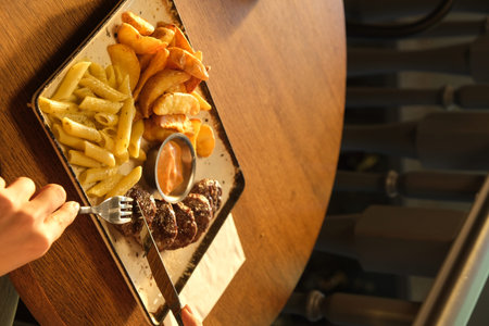 steak with fries on a plate in a restaurant, top view