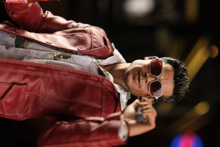 Unidentified man in red leather jacket and sunglasses posing on stage in Bangkok, Thailand.