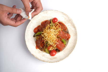 Spaghetti with beef and vegetables in a white plate on a white backgroundの写真素材