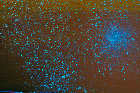 abstract background of colored spots of paint on a dark brown background