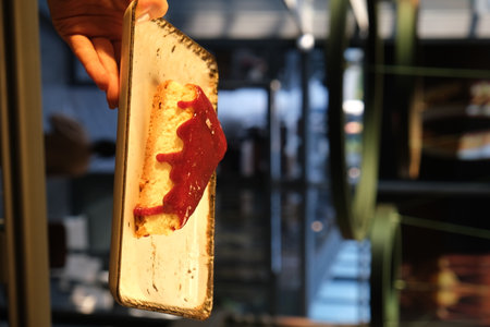 A man's hand holds a piece of cakeの写真素材