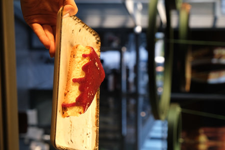 A man's hand holds a piece of cake.の写真素材
