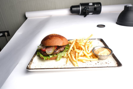 Hamburger with french fries on a white plate in restaurant.の写真素材