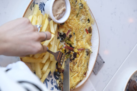 Omelette with french fries on a plate. Selective focus.