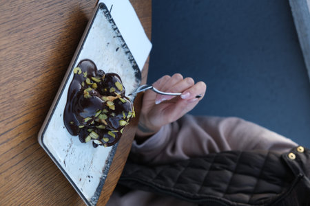 Chocolate cake with nuts on a wooden table in a cafe.