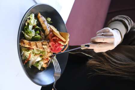 Woman eating salad in restaurant, closeup. Food delivery service conceptの写真素材