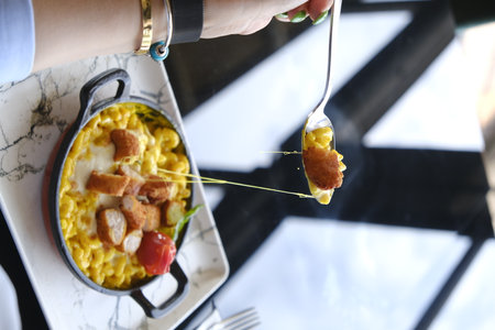 Breakfast with scrambled eggs, bacon and vegetables in a pan.の写真素材