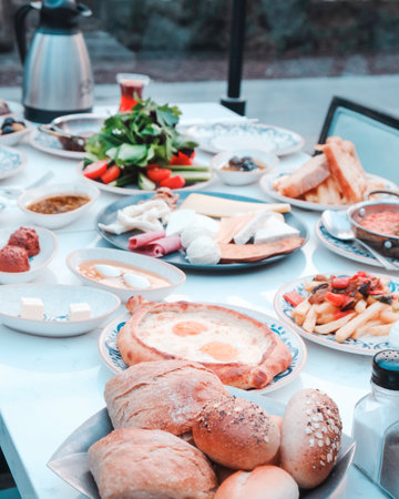 Breakfast table with fried eggs, bread, vegetables and fruits.の写真素材