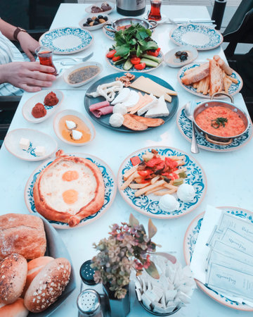 Breakfast table with variety of food and drink on the table.