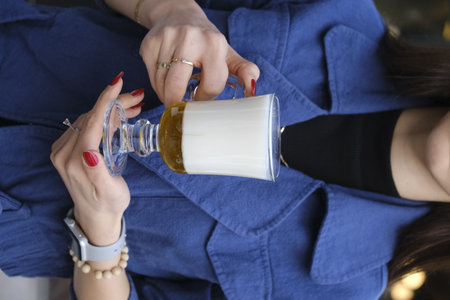 Close-up of a woman's hands holding a glass of milkの写真素材