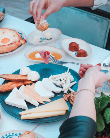 Rich and delicious breakfast. Cropped image of young woman eating breakfast outdoors