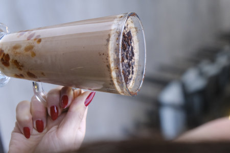 Iced coffee in a glass cup in the hands of a womanの写真素材