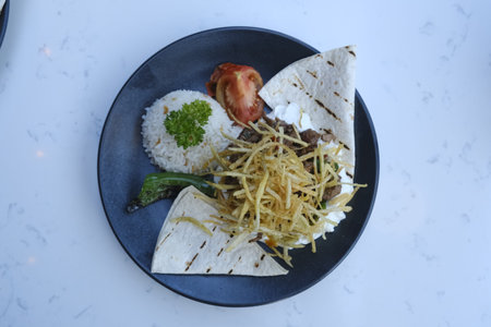 Traditional mexican tacos with beef, cheese, vegetables and rice