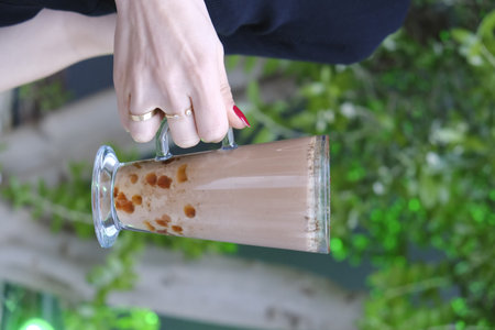 Iced coffee in a glass on the nature background.