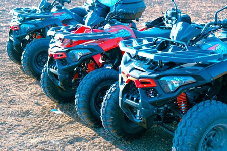 ATV quad bikes parked on the sand in the parking lot.の写真素材
