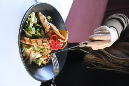 Woman eating salad in restaurant, closeup. Food delivery service conceptの写真素材