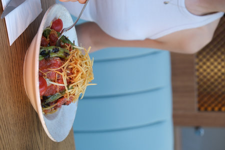 Woman eating fresh salad in the kitchen. Healthy eating concept. close upの写真素材