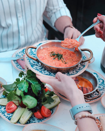Close up of unrecognizable people eating delicious food in restaurant or cafeの写真素材