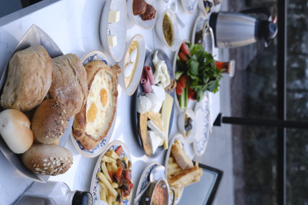 Breakfast table with bread, scrambled eggs and other food on tableの写真素材