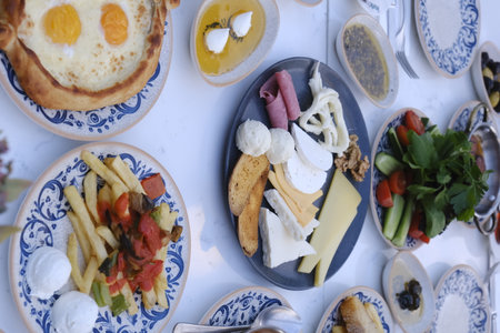 Breakfast with eggs, cheese and vegetables on the table in the restaurantの写真素材