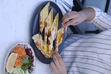 A man is eating a quesadilla in a restaurant.の写真素材