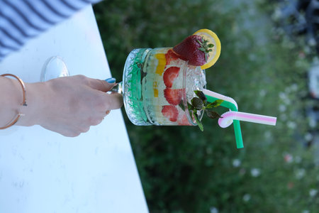Strawberry mojito in a glass jar with a straw.