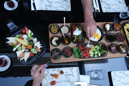 Top view of male hand holding tray with delicious appetizers in restaurantの写真素材