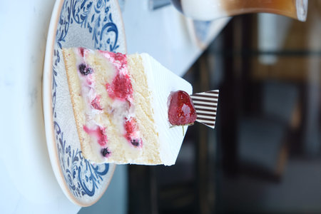 A piece of cake with berries on a plate in a cafe.