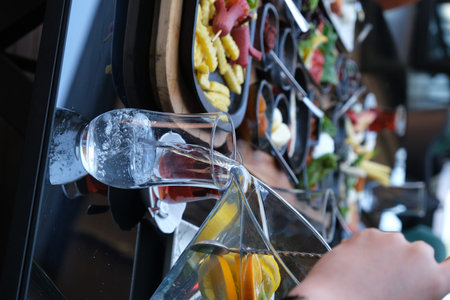 Close-up of ice cubes and glass of cold drink on table
