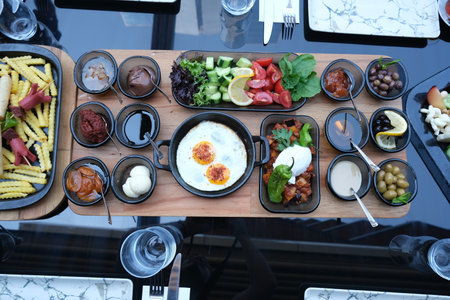 Top view of delicious breakfast with fried eggs and vegetables on wooden tableの写真素材