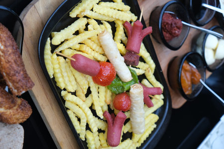 Fried french fries on a black plate, top view