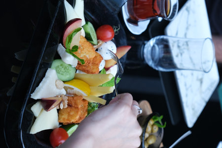 Closeup of a female hand holding a plate of fruit saladの写真素材