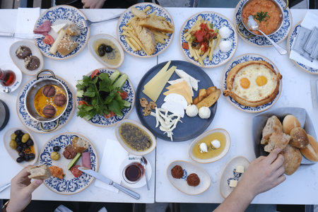 Traditional Turkish and Greek dinner appetizer table with croissants, fried eggs, olives, olives, bread and wineの写真素材