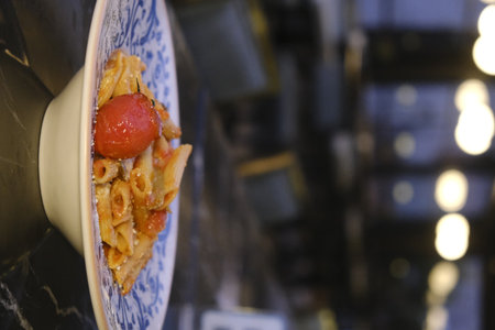 Italian pasta with tomato and cheese on the table in a restaurant.の写真素材