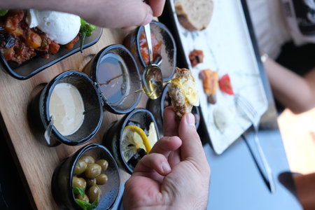 Hands of a man who is eating appetizers with olives.の写真素材