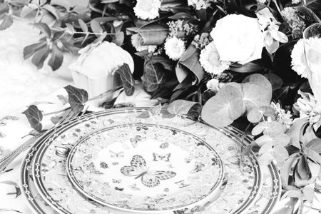 beautiful plate and fresh perfect colorful flowers standing on luxury tableの写真素材