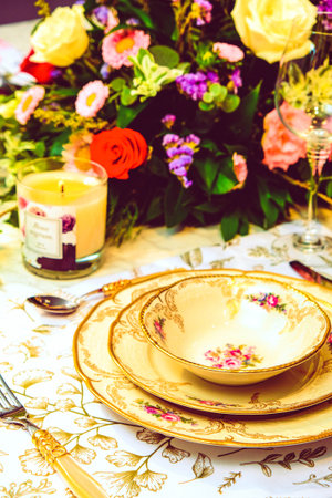 beautiful plate and fresh perfect colorful flowers standing on luxury table