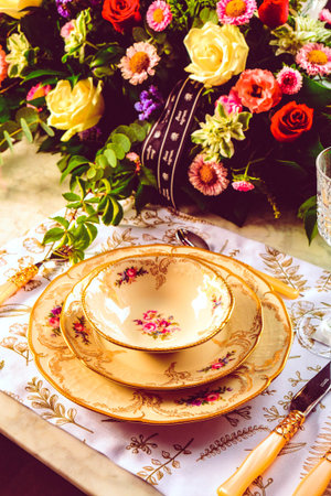 beautiful plate and fresh perfect colorful flowers standing on luxury tableの写真素材