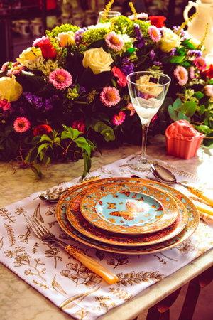 beautiful plate and fresh perfect colorful flowers standing on luxury tableの写真素材