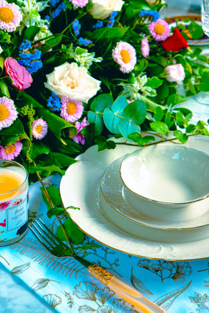 beautiful plate and fresh perfect colorful flowers standing on luxury tableの写真素材