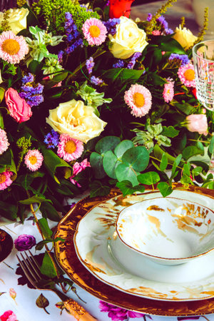 beautiful plate and fresh perfect colorful flowers standing on luxury tableの写真素材