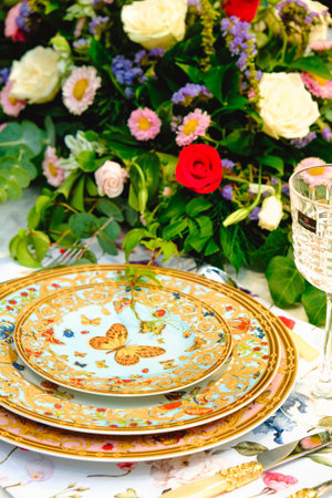 beautiful plate and fresh perfect colorful flowers standing on luxury table