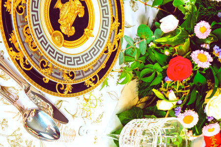 beautiful plate and fresh perfect colorful flowers standing on luxury tableの写真素材