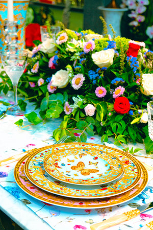 beautiful plate and fresh perfect colorful flowers standing on luxury tableの写真素材