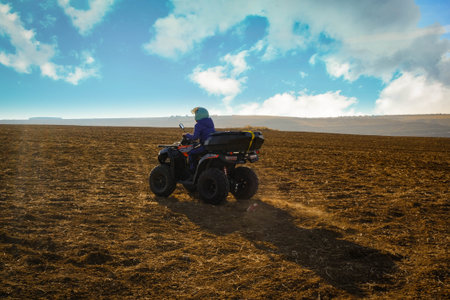 helmet sitting on atv quad bike in mountainsの写真素材