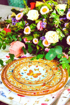 beautiful plate and fresh perfect colorful flowers standing on luxury table
