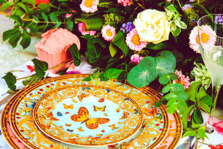 beautiful plate and fresh perfect colorful flowers standing on luxury tableの写真素材