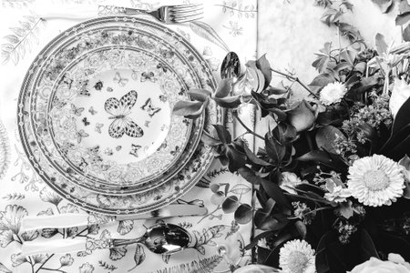 beautiful plate and fresh perfect colorful flowers standing on luxury tableの写真素材