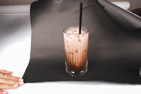 A glass of iced coffee with a strawの写真素材